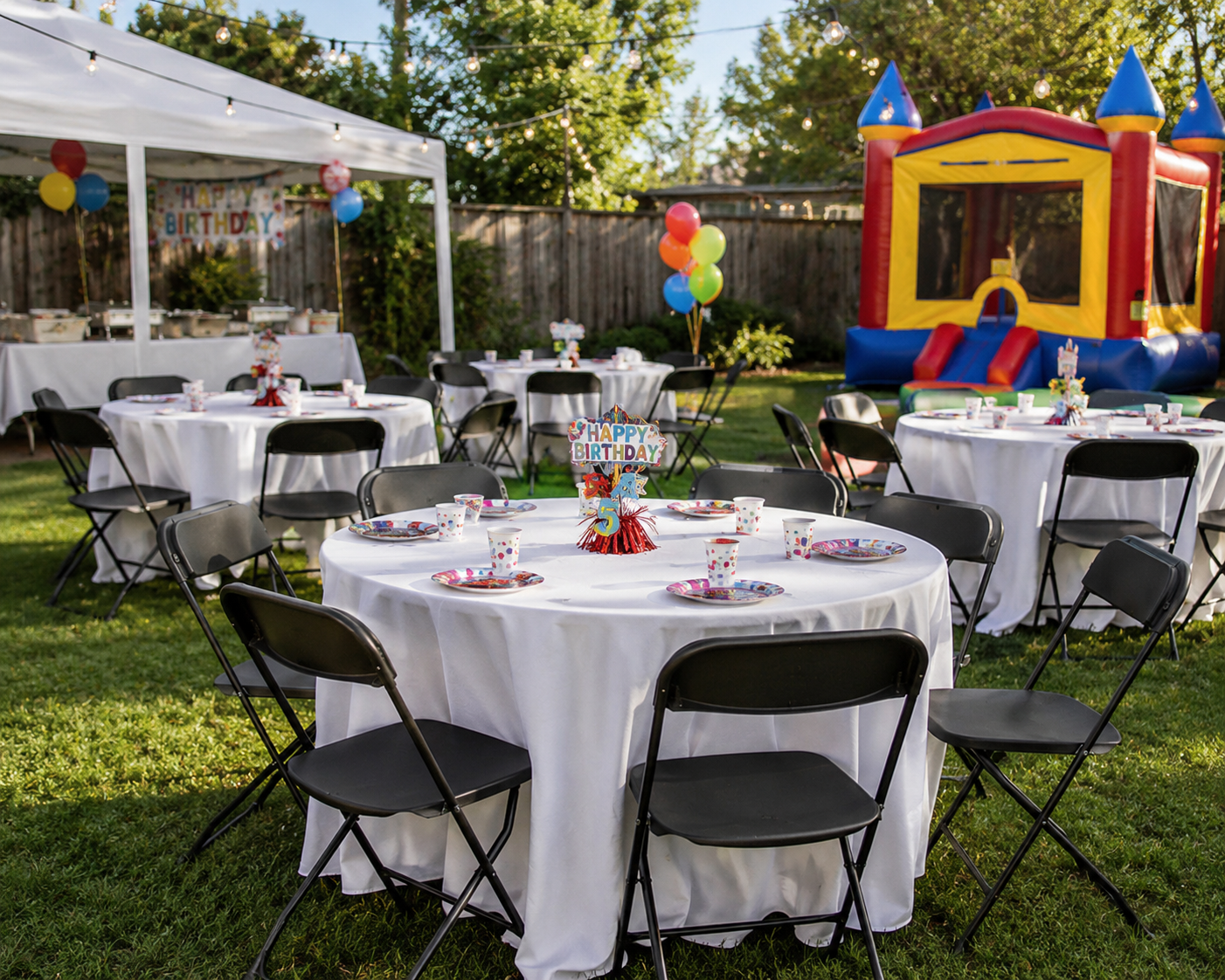 Black Folding Chairs at a Backyard Birthday Party Black commercial folding chairs arranged around decorated tables at a backyard birthday party with balloons and a bounce house.
