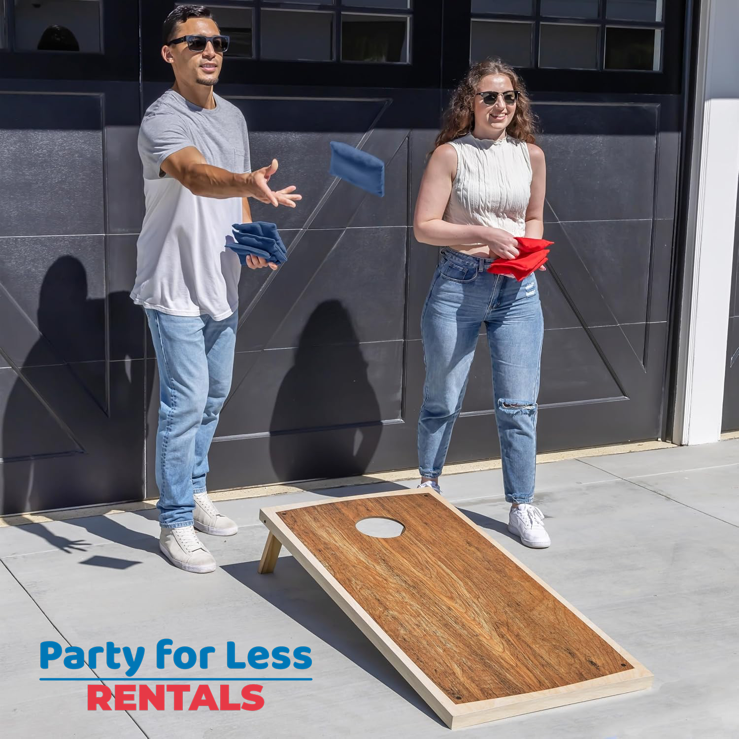 Classic Cornhole Game for Backyard & Driveway Parties | Party For Less Rentals Aurora Denver CO Party For Less Rentals classic wood design cornhole set couple playing in driveway Aurora Denver Colorado